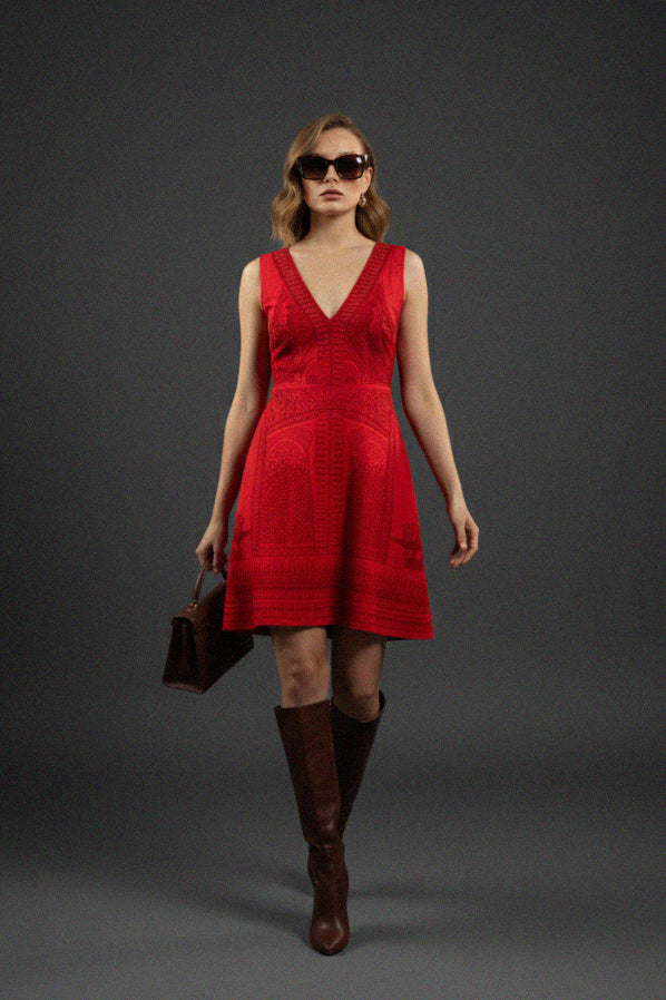 Shahida Parides red V neck mini dress woman model wearing brown boots and sunglasses holding handbag high fashion editorial look