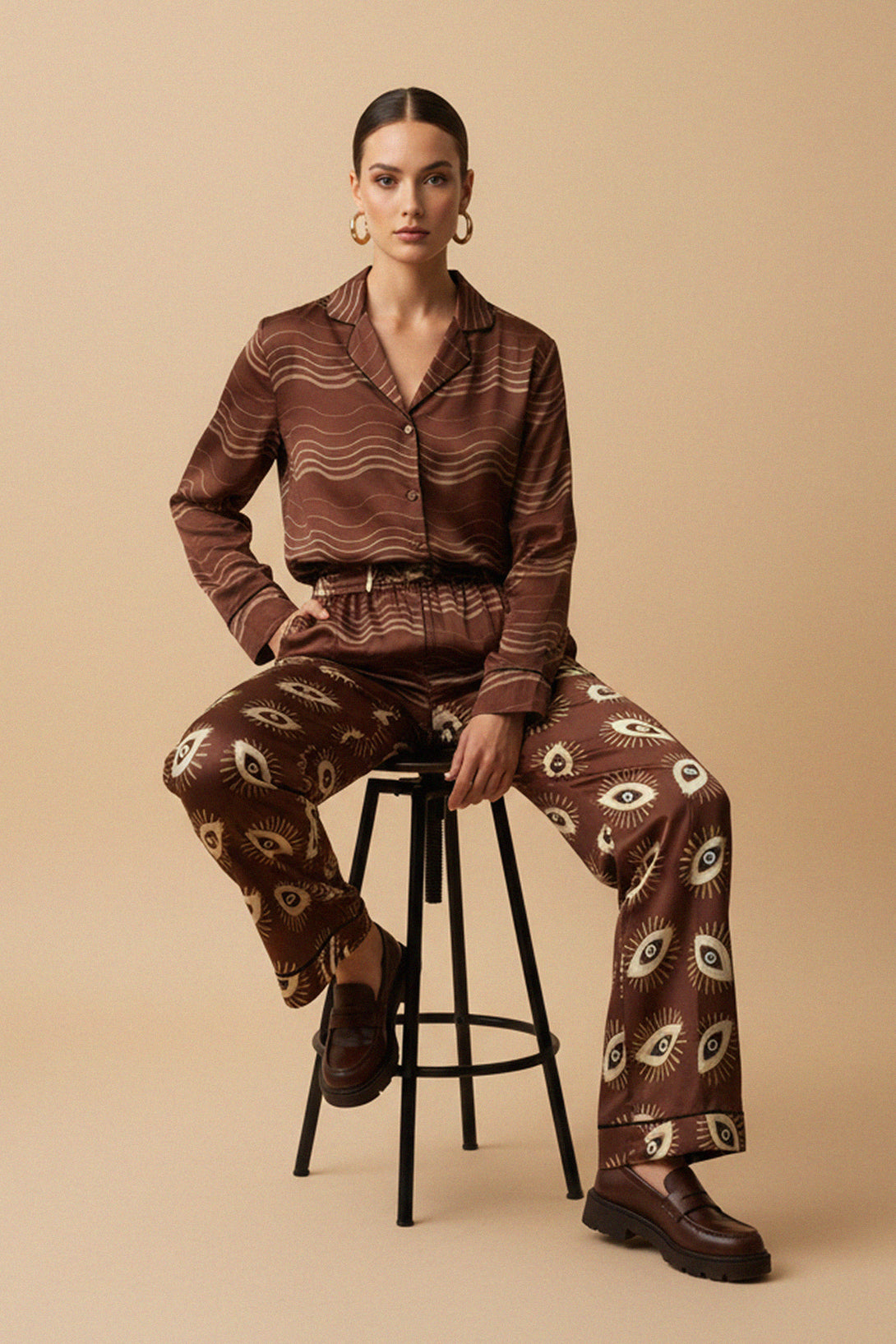 seated pose, stripe blouse, brown top, chic fashion, soft waves, long sleeves, modern look