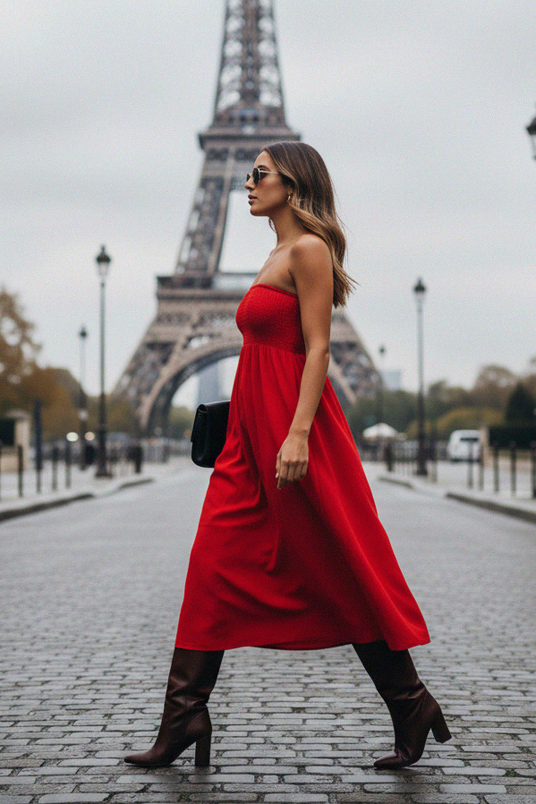 Stylish off-shoulder red midi dress paired with boots and a clutch, photographed in front of the Eiffel Tower.