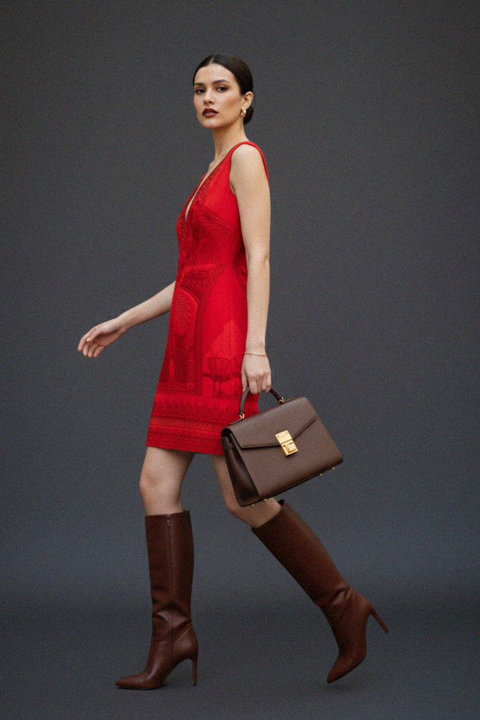 Shahida Parides red luxury dress woman walking stylish brown leather boots and handbag elegant modern fashion look